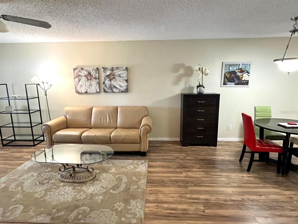 1550 South Belcher Road, Unit 524 Clearwater, FL 33764 - Photo 5 of 45 a living room with furniture and a dining table with bookshelf