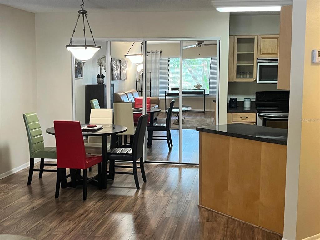 1550 South Belcher Road, Unit 524 Clearwater, FL 33764 - Photo 7 of 45 a dining room with furniture a chandelier and wooden floor