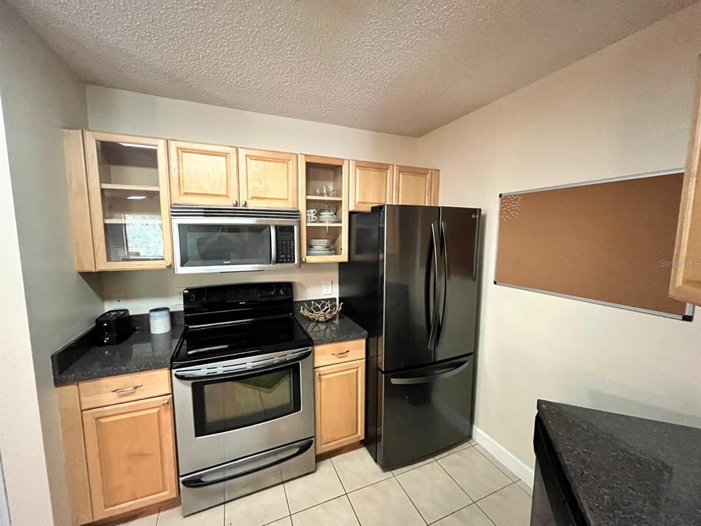 1550 South Belcher Road, Unit 524 Clearwater, FL 33764 - Photo 9 of 45 a kitchen with stainless steel appliances granite countertop a refrigerator stove and sink