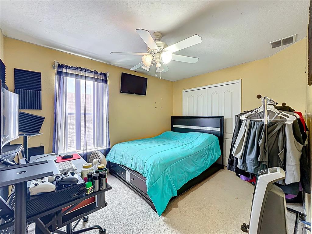 7939 Riffle Lane Orlando, FL 32818 - Photo 31 of 52 a bedroom with a bed and a chandelier