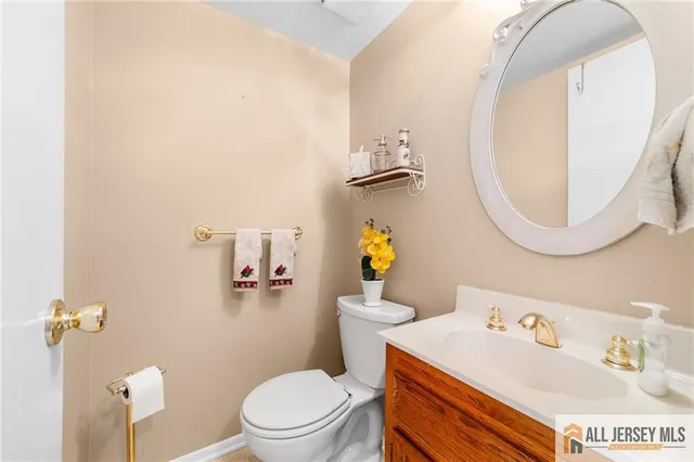 a bathroom with a sink mirror vanity and toilet