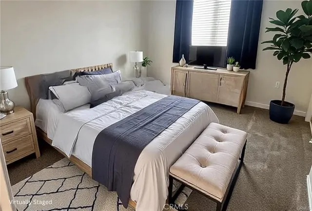 a bedroom with a bed and a flat tv screen on dresser
