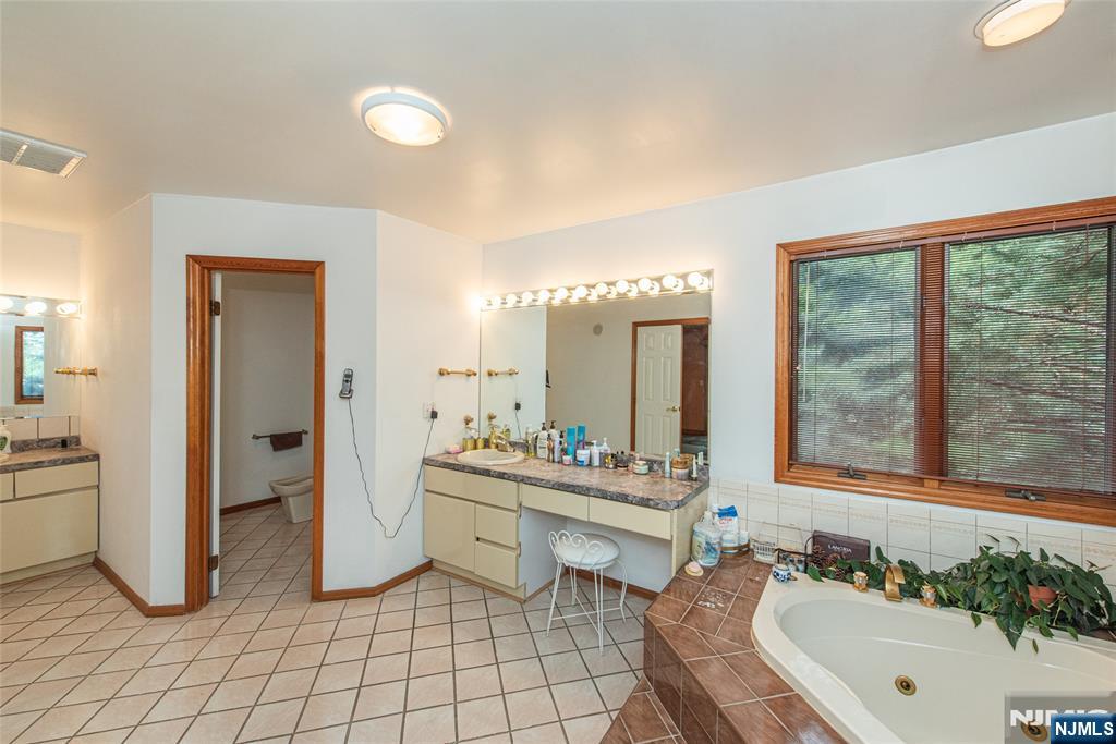 12 Abbott Road Wayne, NJ 07470 - Photo 26 of 49 a spacious bathroom with a double vanity sink a mirror and a bathtub