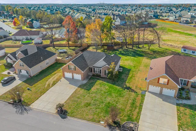 an aerial view of a house with a garden and lake view