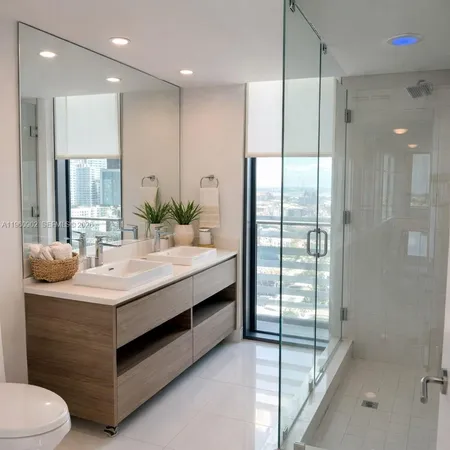 a bathroom with a double vanity sink toilet and shower