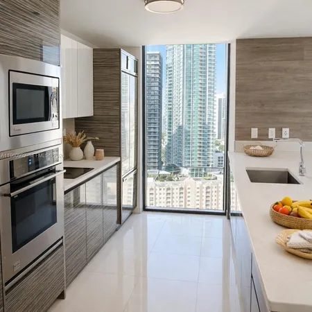 a kitchen with stainless steel appliances wooden floor and a stove top oven
