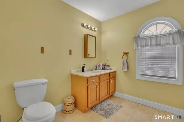a bathroom with a toilet a sink and a window
