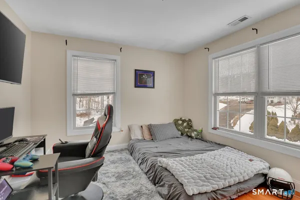 a bedroom with a bed and wooden floor