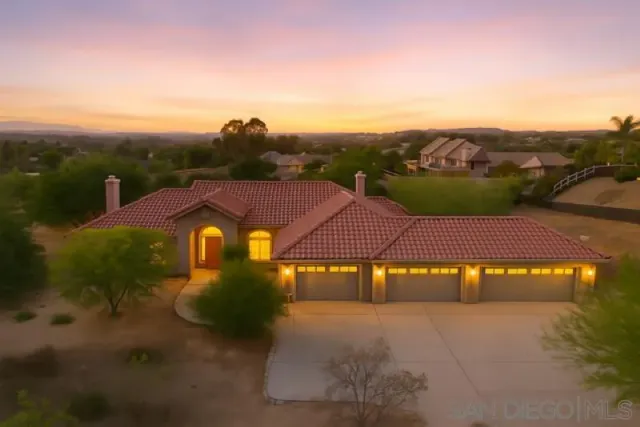 a view of a big house with a big yard and large tree