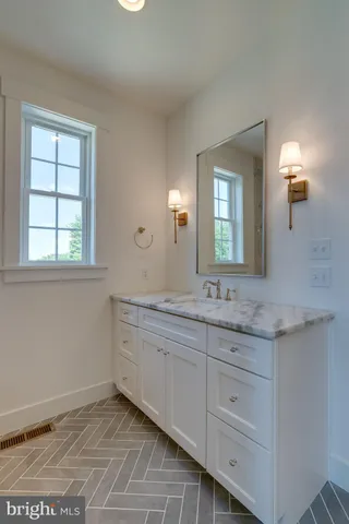 a bathroom with a granite countertop sink and a mirror