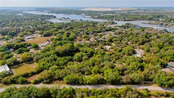 an aerial view of a houses with a yard and lake view