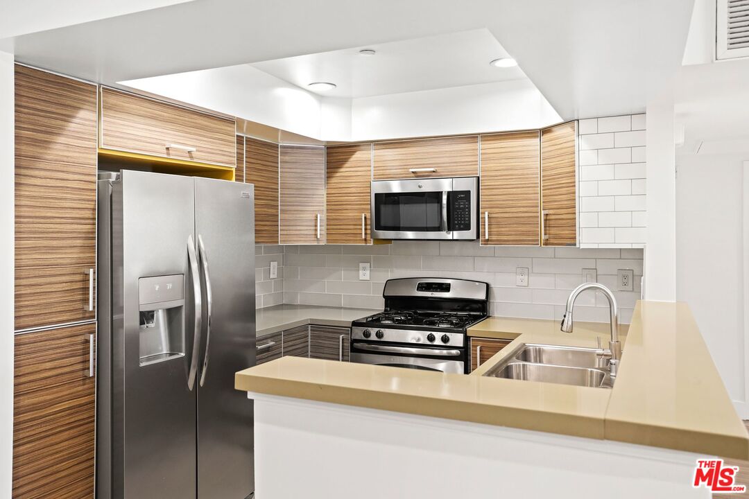 a kitchen with stainless steel appliances a refrigerator stove and microwave