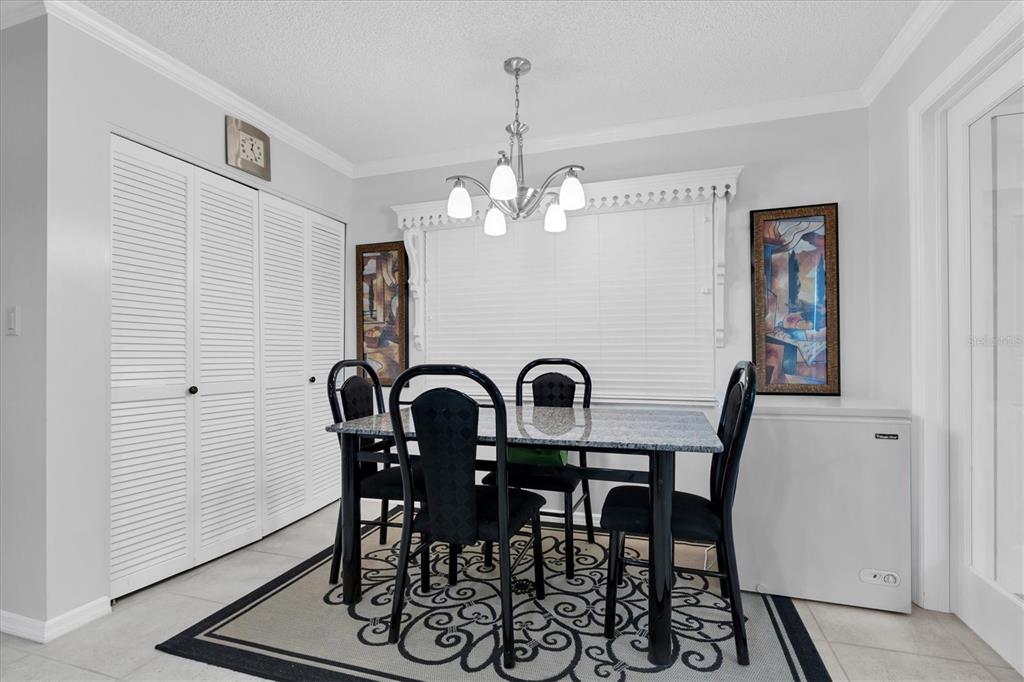 6500 Sunset Way, Unit 316 St. Pete Beach, FL 33706 - Photo 11 of 58 a view of a dining room with furniture and chandelier