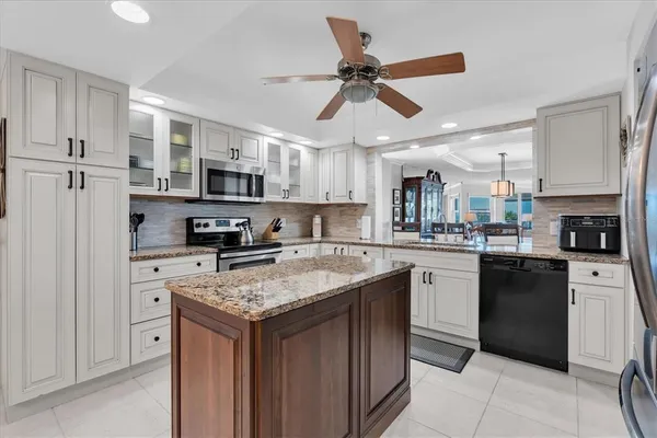 a kitchen with stainless steel appliances granite countertop a stove top oven a refrigerator a sink and dishwasher