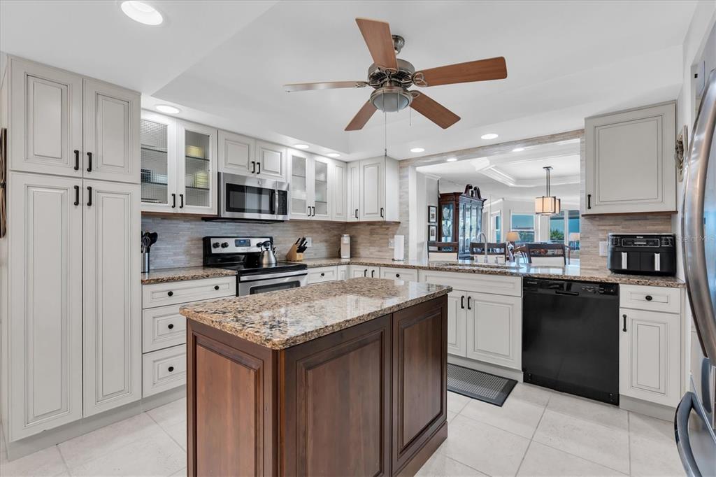 6500 Sunset Way, Unit 316 St. Pete Beach, FL 33706 - Photo 13 of 58 a kitchen with stainless steel appliances granite countertop a stove top oven a refrigerator a sink and dishwasher