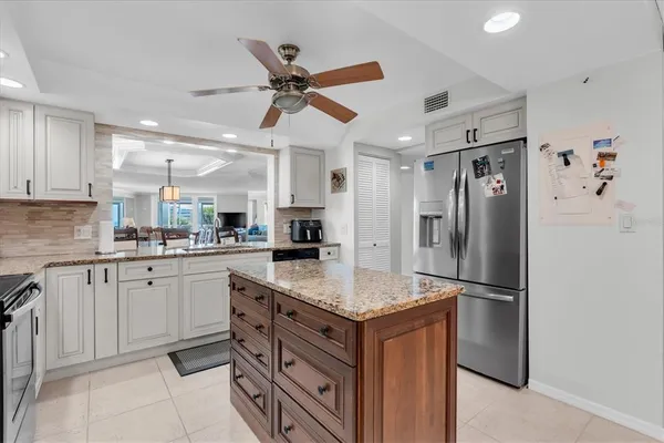 a kitchen with stainless steel appliances granite countertop a refrigerator and a sink