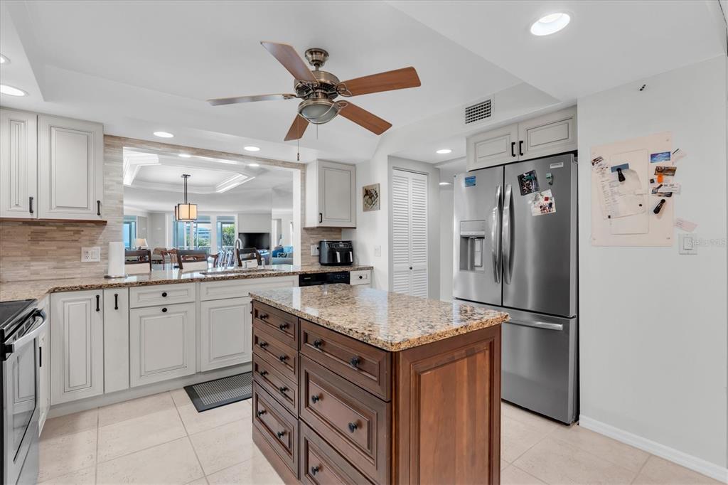 6500 Sunset Way, Unit 316 St. Pete Beach, FL 33706 - Photo 14 of 58 a kitchen with stainless steel appliances granite countertop a refrigerator and a sink
