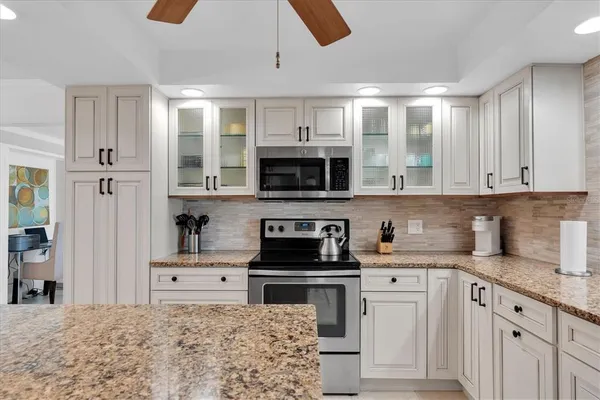 a kitchen with granite countertop a stove sink and cabinets