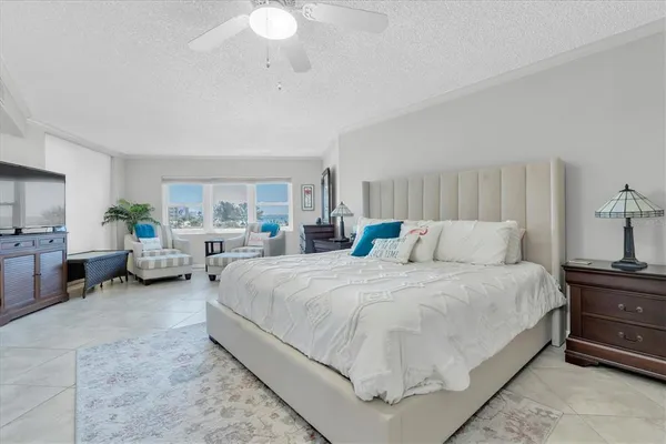 a spacious bedroom with a bed a couch and dresser