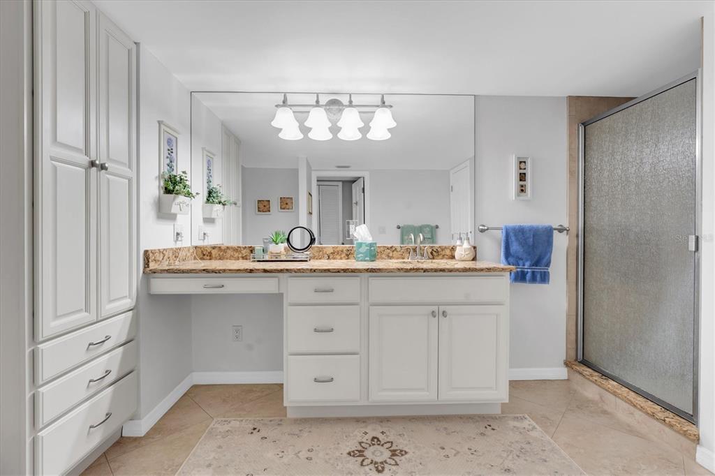 6500 Sunset Way, Unit 316 St. Pete Beach, FL 33706 - Photo 23 of 58 a bathroom with a double vanity sink and a mirror