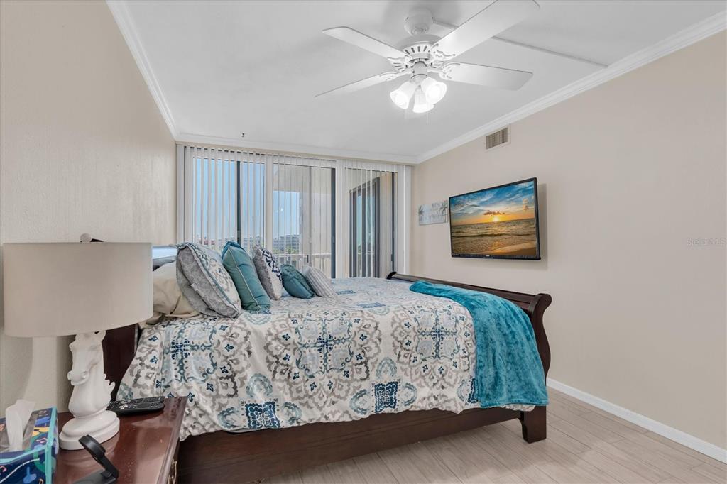 6500 Sunset Way, Unit 316 St. Pete Beach, FL 33706 - Photo 30 of 58 a bedroom with a large bed and a chandelier