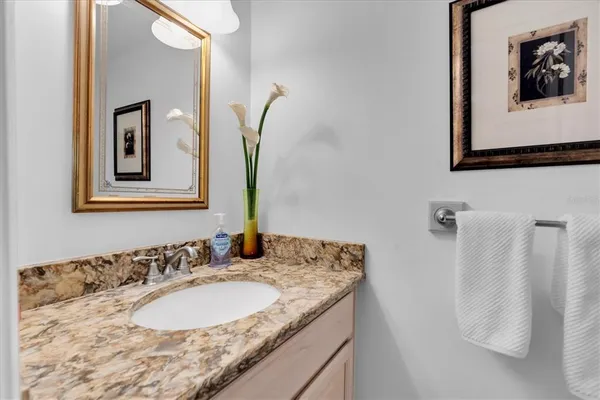 a bathroom with a granite countertop sink and a mirror