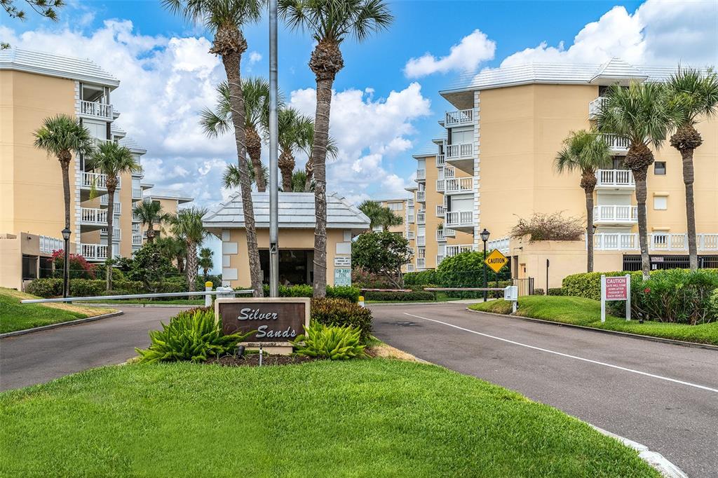 6500 Sunset Way, Unit 316 St. Pete Beach, FL 33706 - Photo 46 of 58 a view of a fountain in front of a brick house