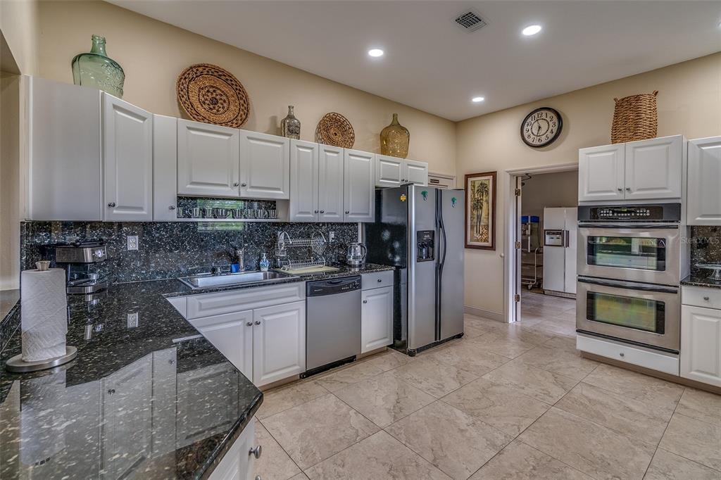 6500 Sunset Way, Unit 316 St. Pete Beach, FL 33706 - Photo 54 of 58 a kitchen with stainless steel appliances granite countertop a refrigerator and a stove top oven