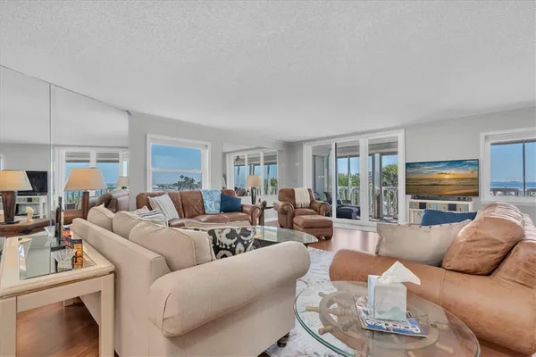 a living room with furniture a flat screen tv and a large window