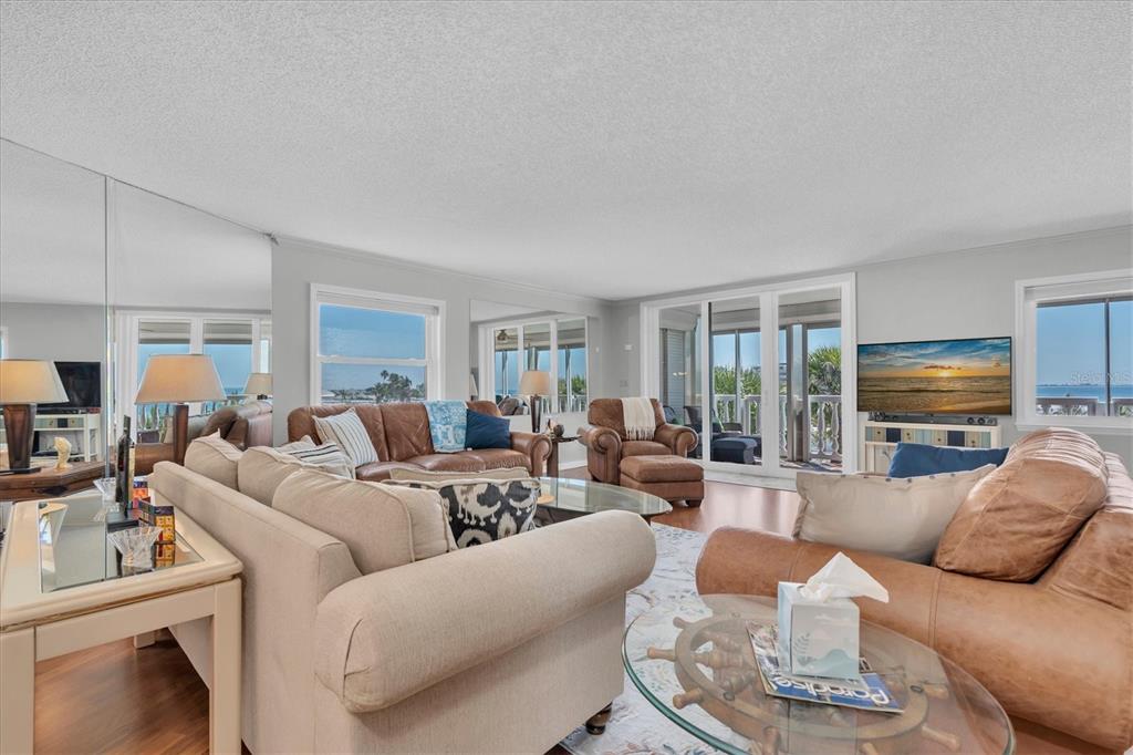 6500 Sunset Way, Unit 316 St. Pete Beach, FL 33706 - Photo 8 of 58 a living room with furniture a flat screen tv and a large window