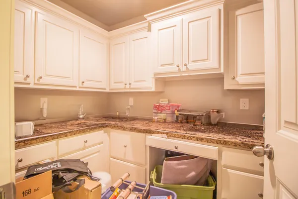 a kitchen with granite countertop white cabinets and sink