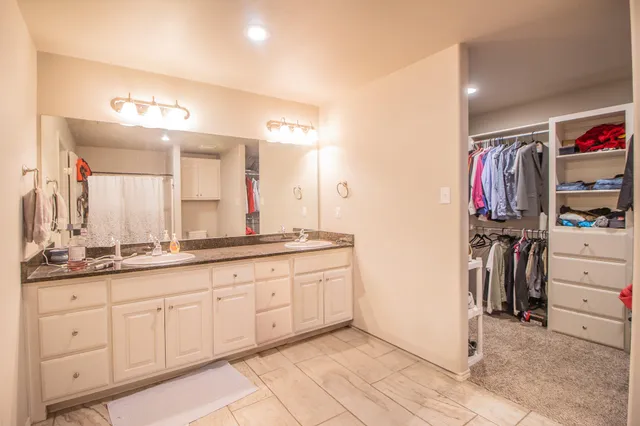 a bathroom with a double vanity sink and a mirror