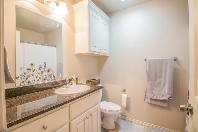 a bathroom with a granite countertop sink and a mirror