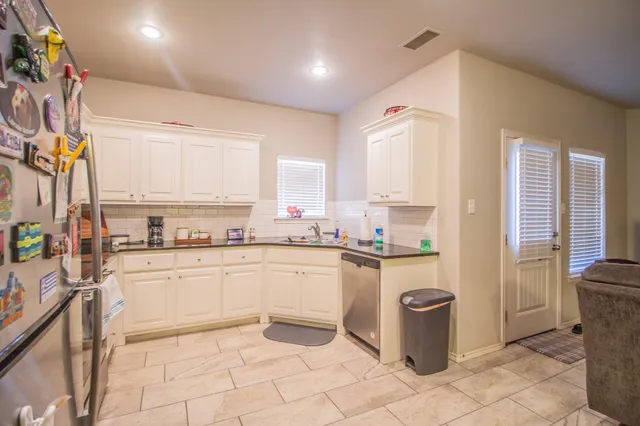 a kitchen with a refrigerator sink and cabinets