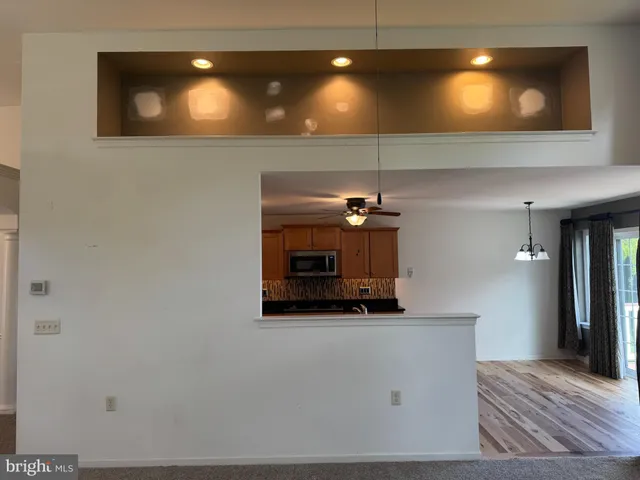 a kitchen with kitchen island granite countertop a refrigerator a stove top oven a sink dishwasher and wooden cabinets