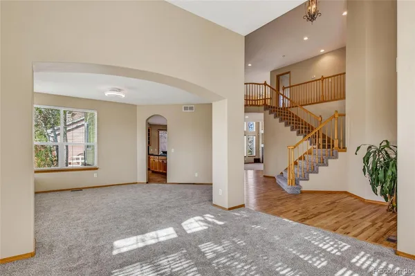 a view of empty room with stairs and wooden floor