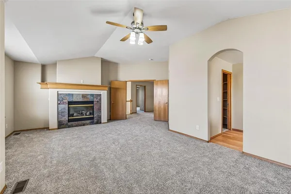 an empty room with windows and fireplace