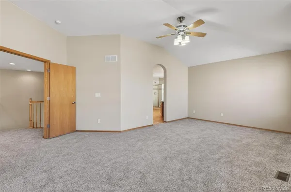 an empty room with closet and a ceiling fan