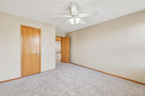 an empty room with a ceiling fan and a window
