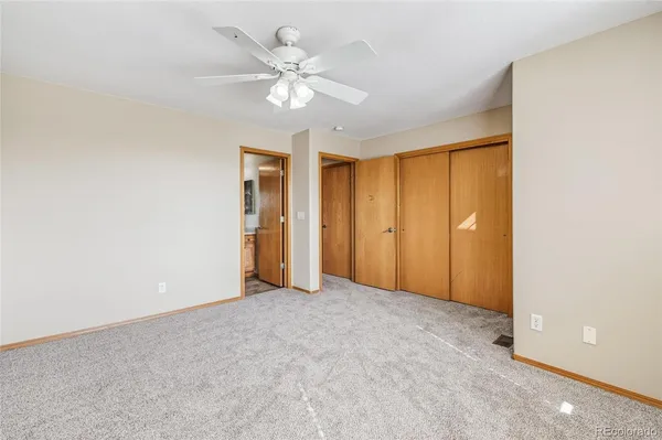 a view of an empty room with a chandelier fan