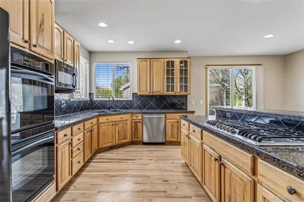a large kitchen with stainless steel appliances granite countertop a stove and a sink