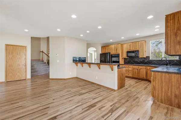 a view of kitchen with wooden floor and electronic appliances