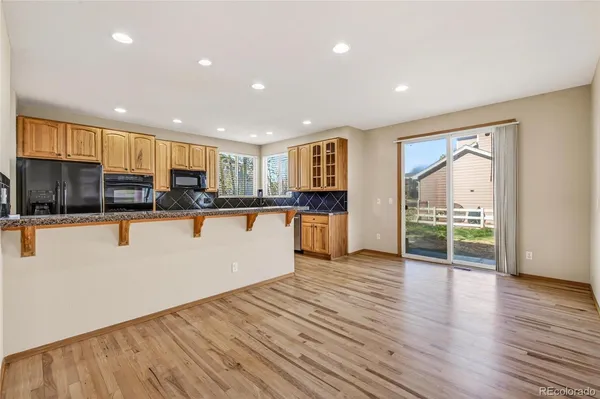 a view of kitchen with refrigerator stove and wooden floor