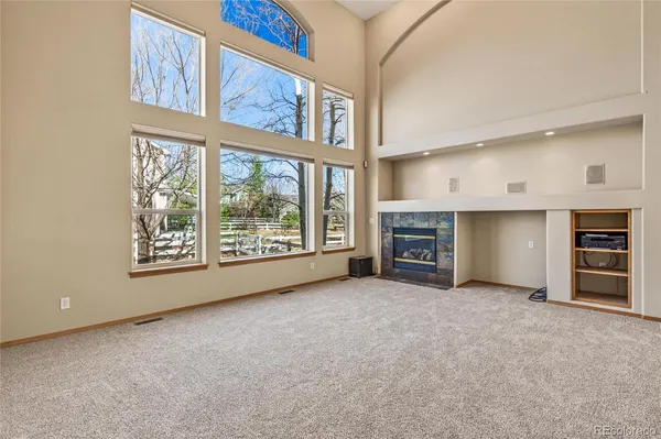 a view of an empty room with a fireplace and a window