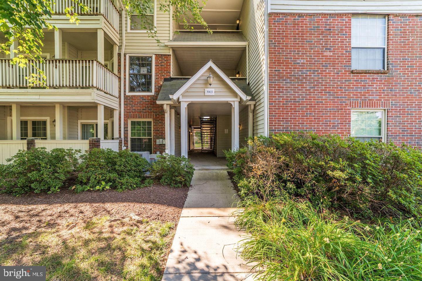 3903 Penderview Drive, Unit 1505 Fairfax, VA 22033 - Photo 1 of 20 a view of a brick house with many windows next to a yard