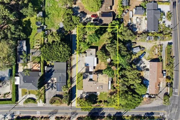 an aerial view of residential house with outdoor space and trees all around