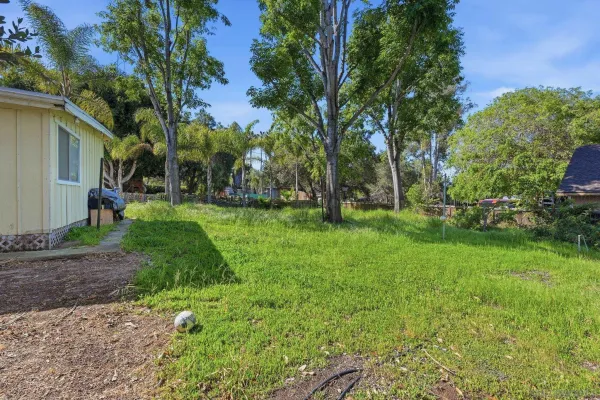 a view of a house with backyard and trees