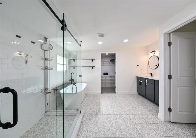 a bathroom with a double vanity sink a toilet a mirror and shower