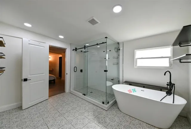 a bathroom with a granite countertop tub shower and sink