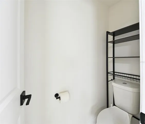 a white toilet sitting next to a shower